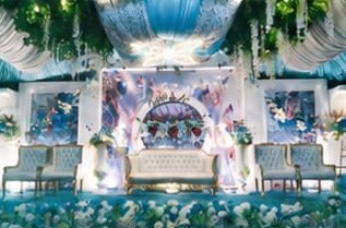 Pelaminan dengan dekorasi bunga biru putih dan kursi pengantin
