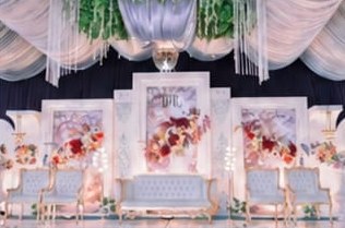 Pelaminan putih dengan panel bunga merah dan tirai gantung